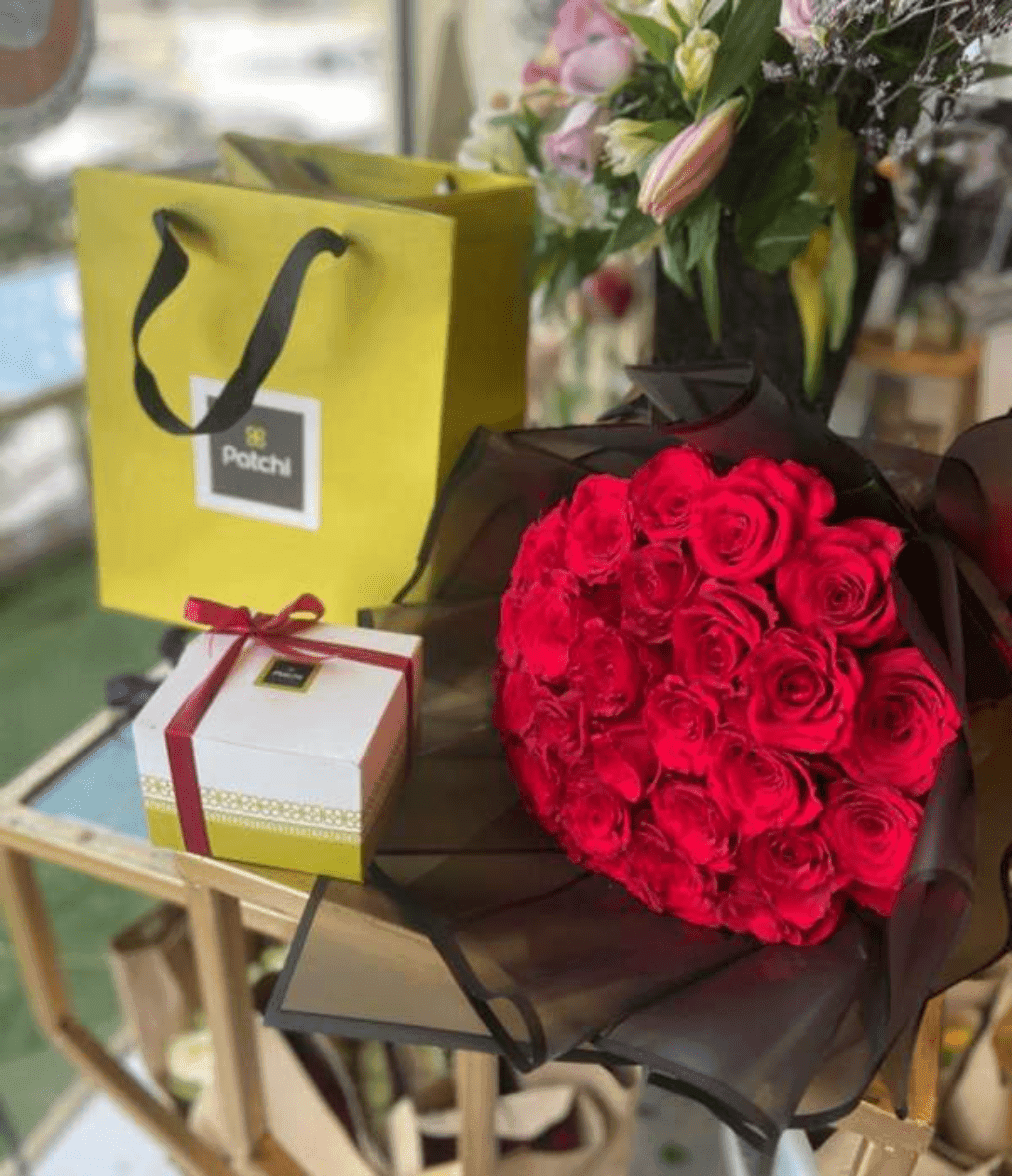 Bouquet de fleurs rouge bien emballé avec chocolat Patchi
