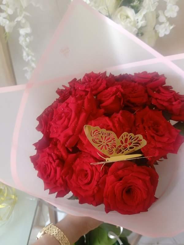 Bouquet de fleurs rouge emballage rose avec motif papillon
