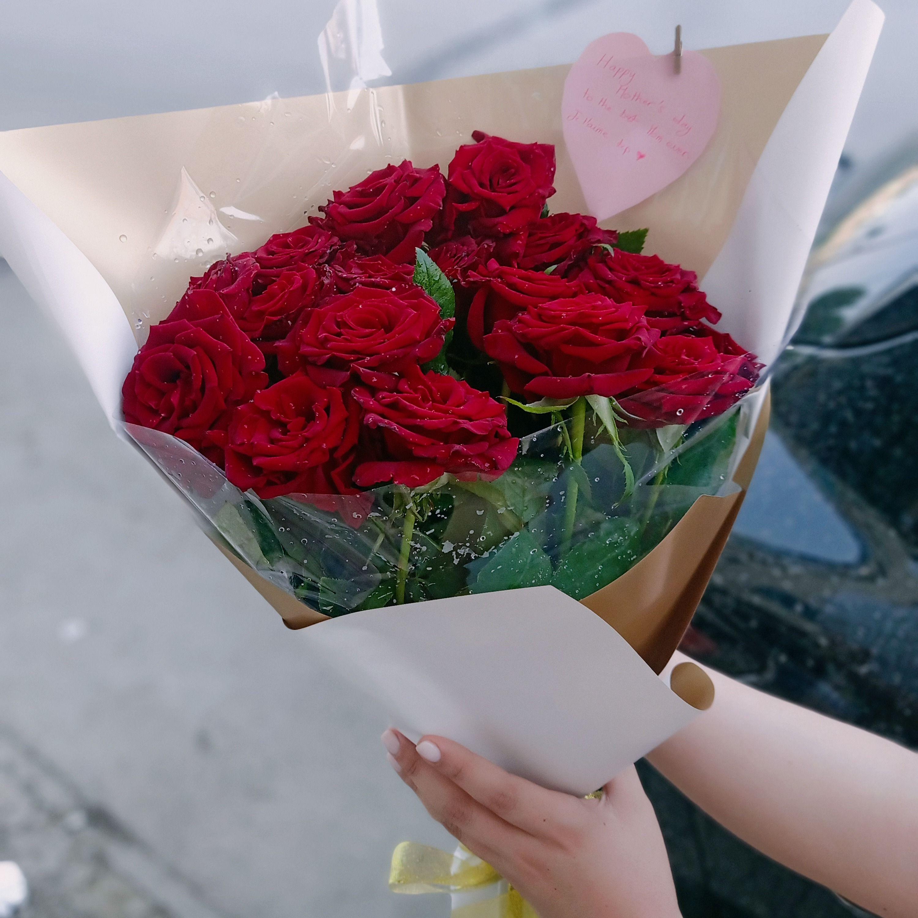 Bouquet de roses rouges avec un élégant emballage rose clair