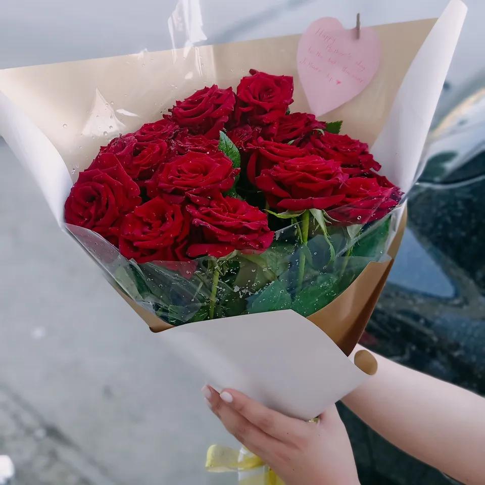 Bouquet de roses rouges avec un élégant emballage rose clair