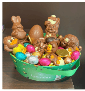 Panier avec un assortiment de sujets de paques et de petits œufs et pralines de paques